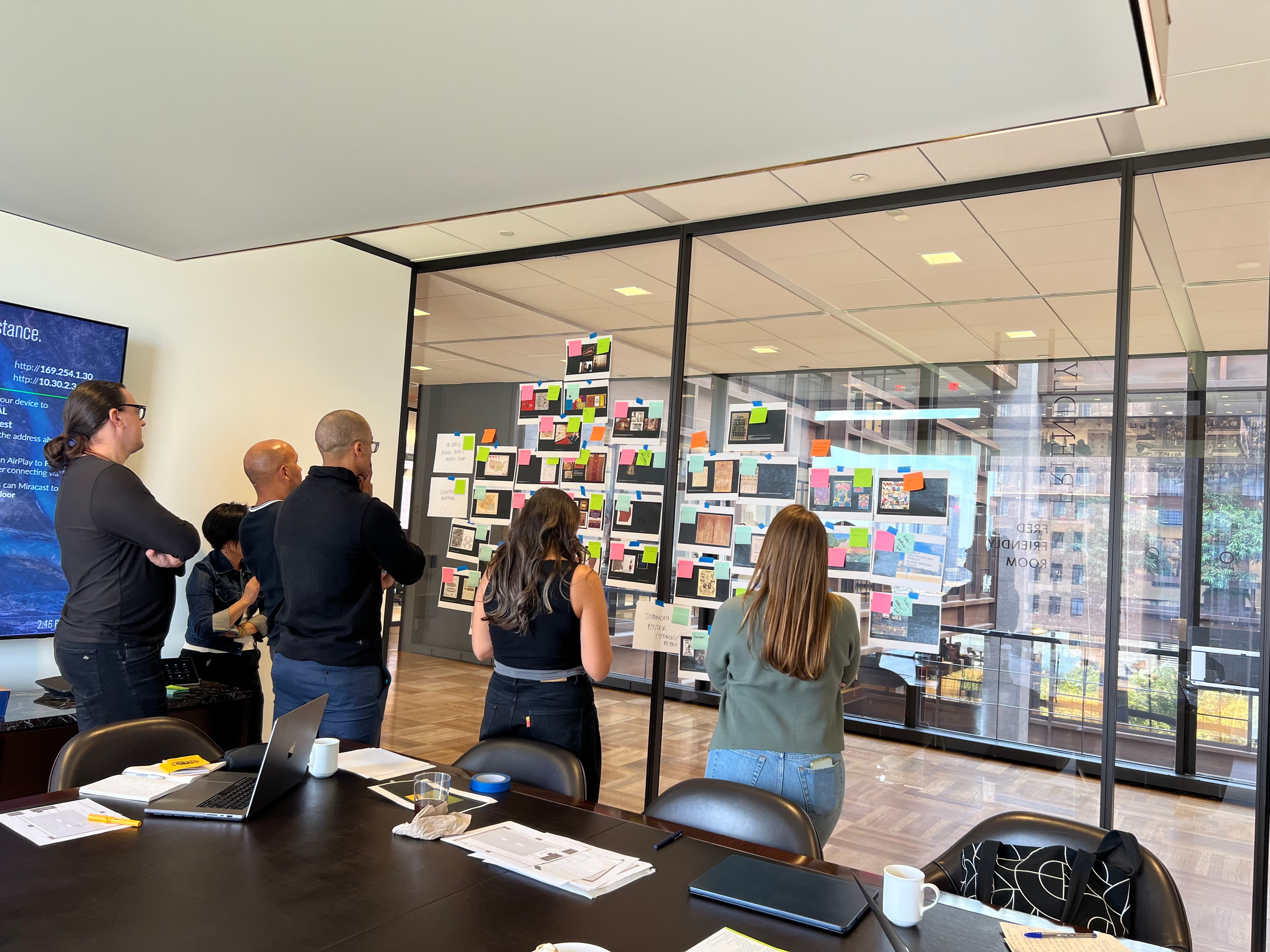 Team members looking at a wall of post-its for ideation
